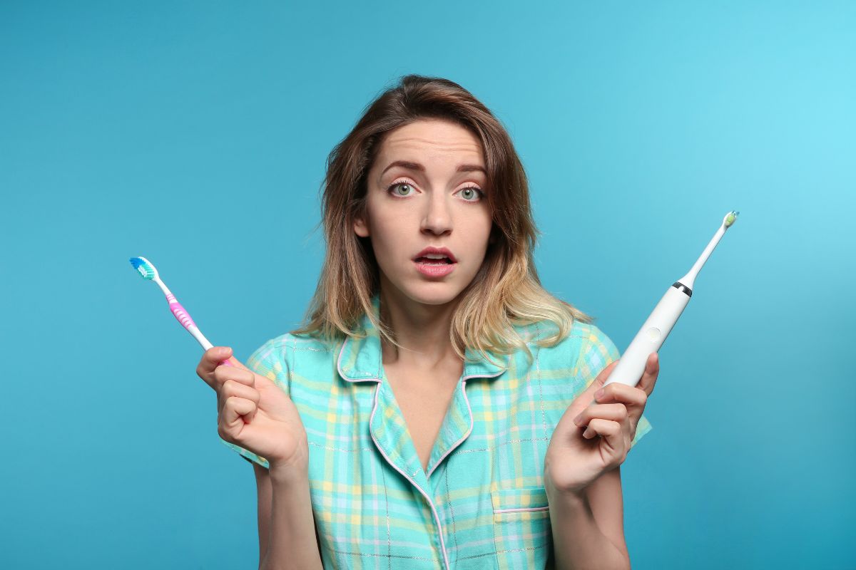 Do You Need a New Toothbrush Excited woman in checkered shirt holding toothbrushes against blue background.